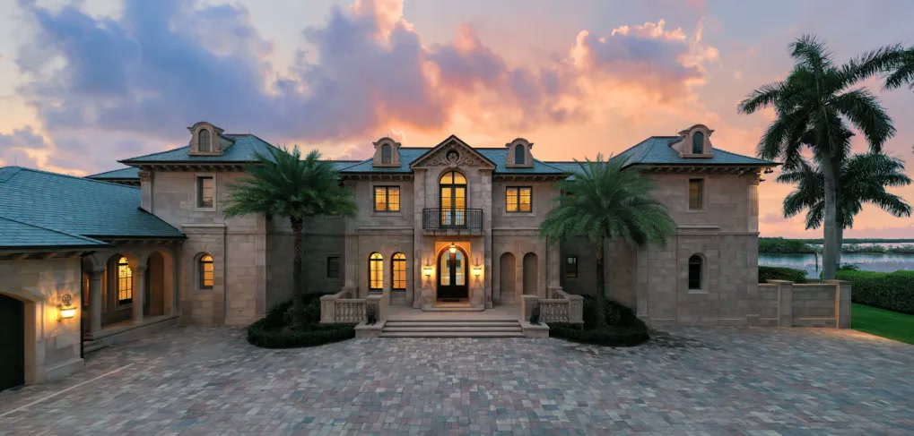 Formal stone front elevation beneath dramatic evening clouds