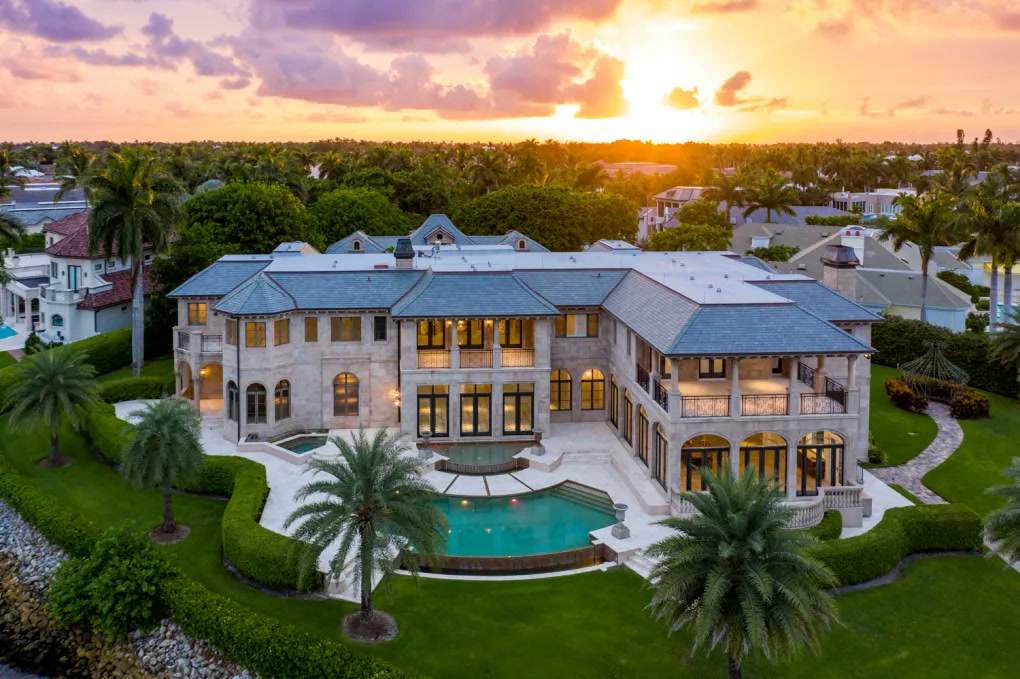 Aerial view of a grand waterfront estate at sunset