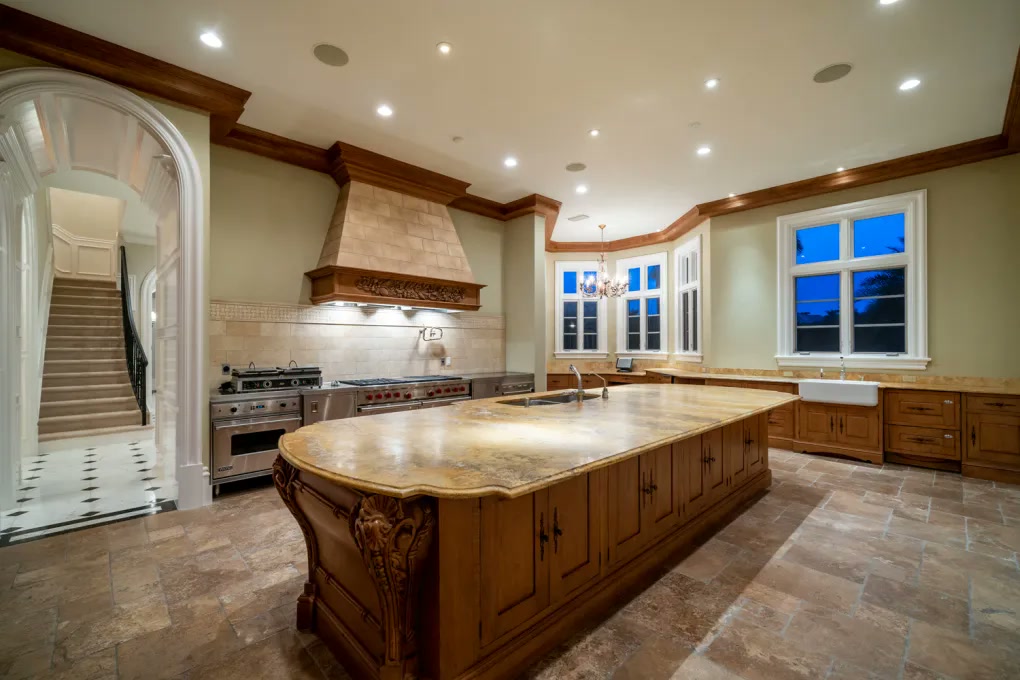 Traditional wood kitchen with carved island and stone floor