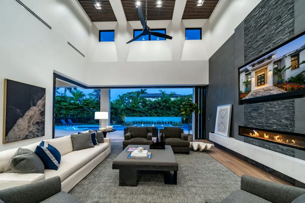 Living room with floor-to-ceiling fireplace and pool view