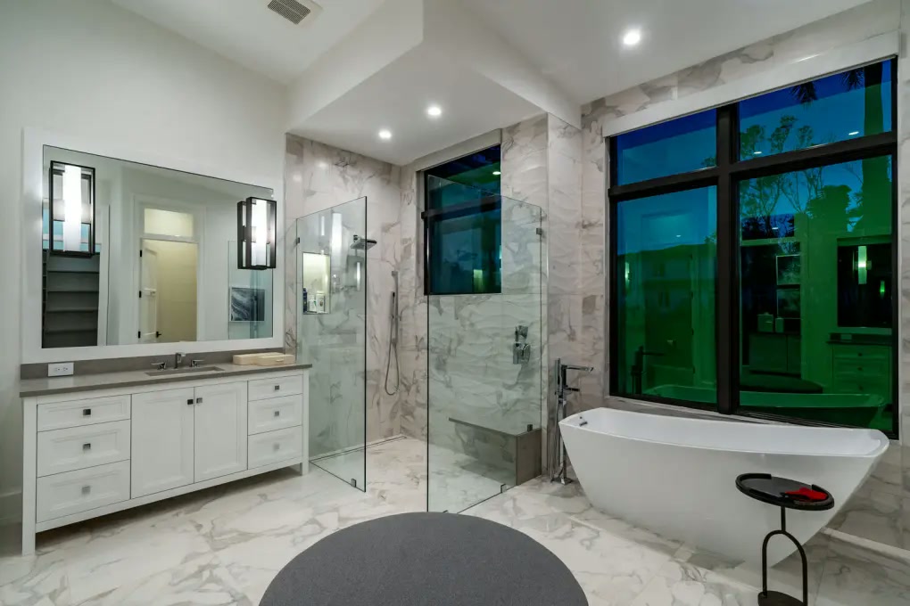 Marble primary bathroom with freestanding tub and glass shower