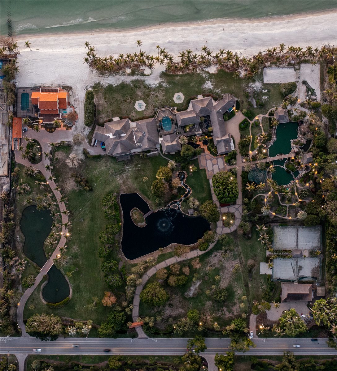 Vertical aerial showing landscaped grounds between road and beach
