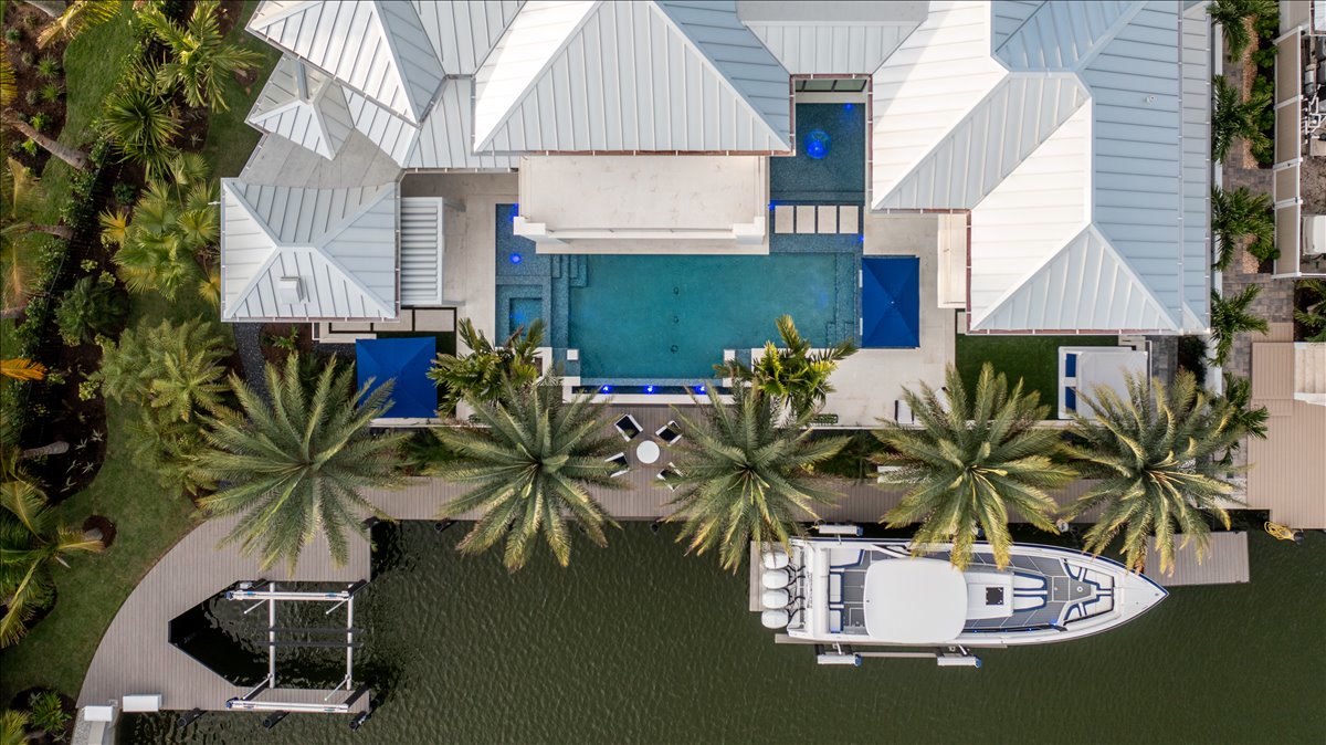 Vertical aerial showing the pool terrace, dock, and canal