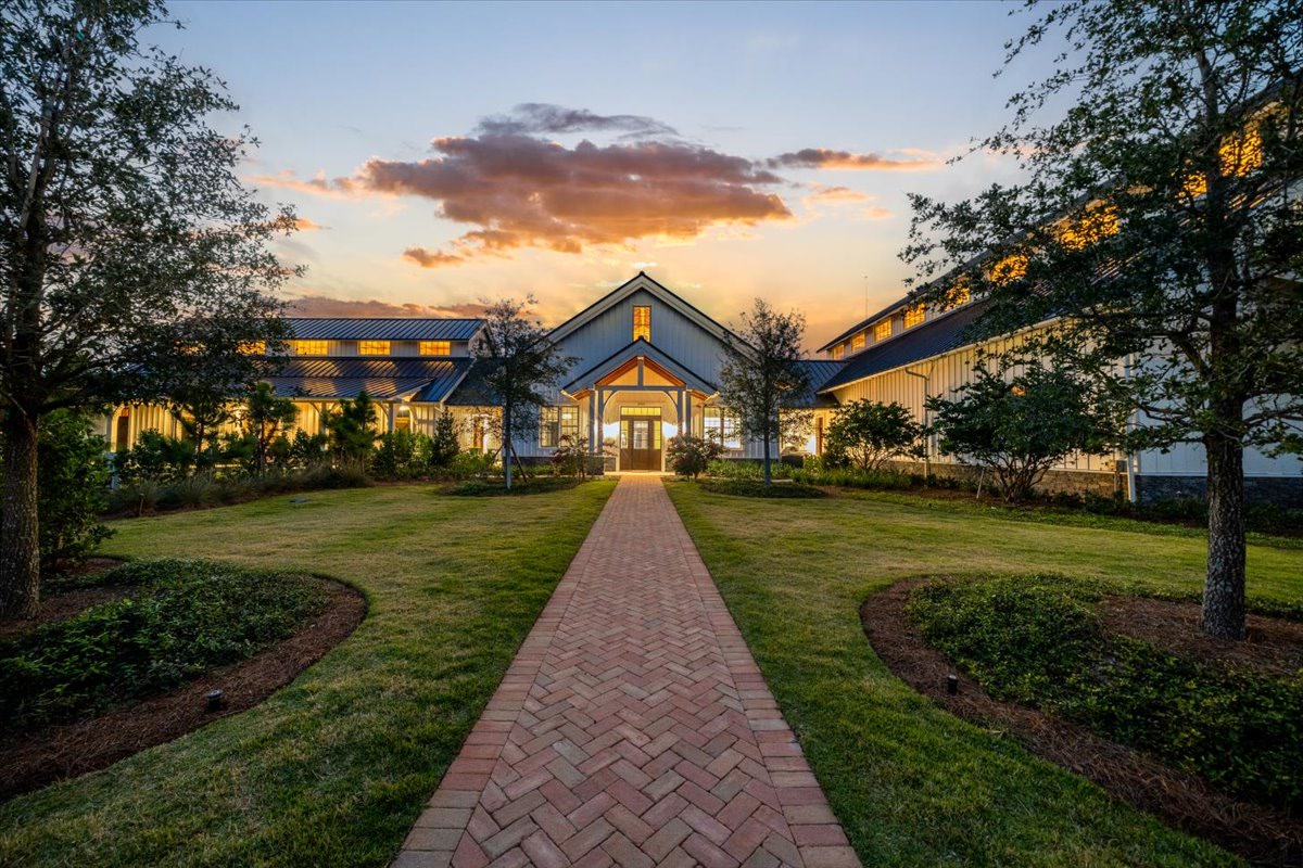 Long brick path leading to a barn-inspired main entry