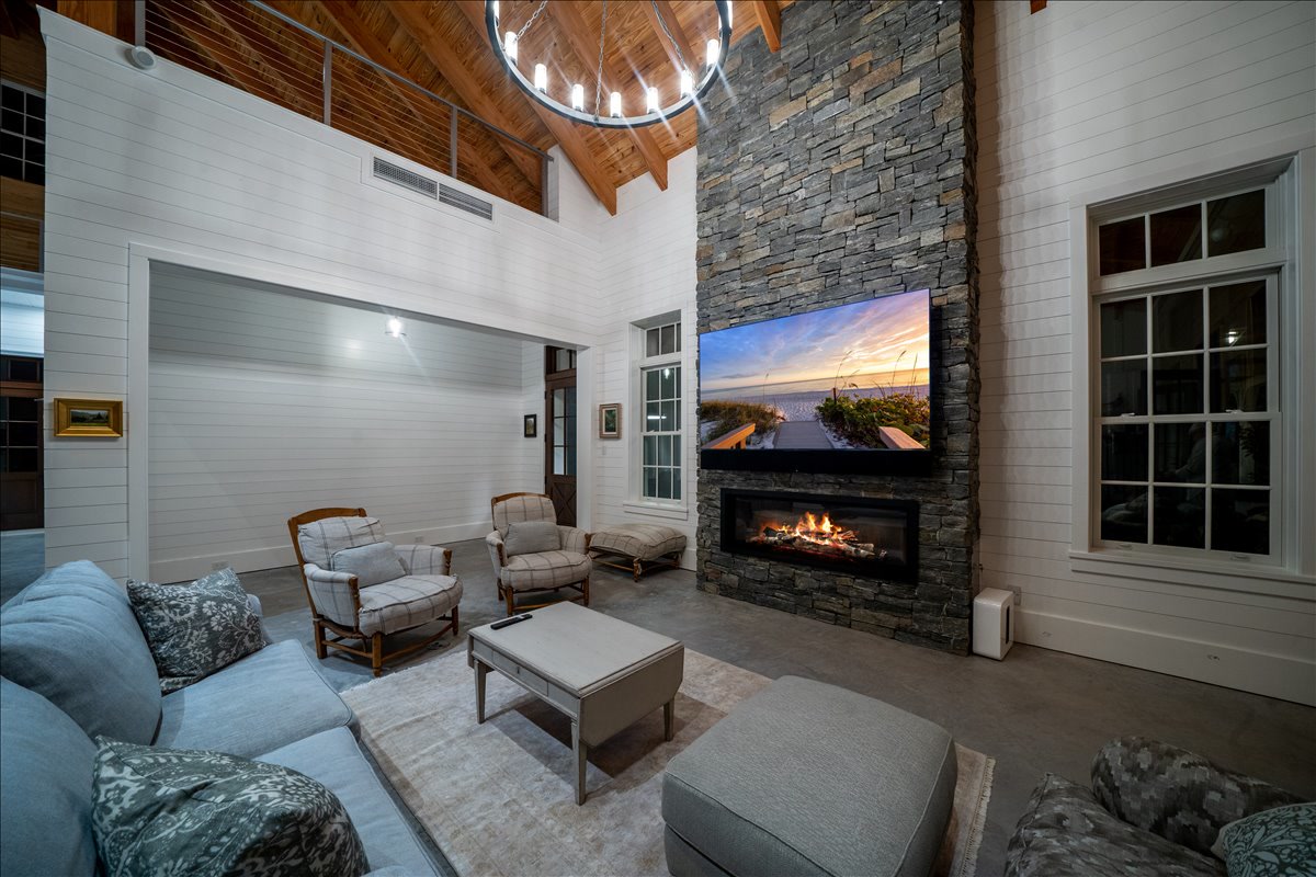 Double-height living area with stone fireplace and timber ceiling